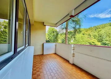 Geräumiger Balkon mit Fliesenboden und weitem Blick ins Grüne, ideal zum Entspannen.