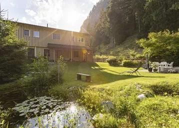Großzügiger Gartenbereich mit Teich, Liegewiese und Sitzgelegenheiten vor dem Haus in sonniger Lage.