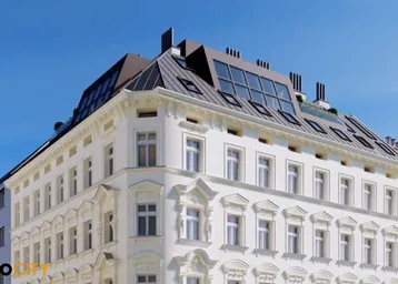 Historische Fassade eines Gebäudes mit modernem Dachausbau und vielen Fenstern.