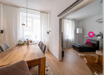 Heller Essbereich mit großem Holztisch und Zugang zum Wohnzimmer, ausgestattet mit modernen Leuchten.