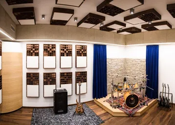 Professionelles Musikstudio mit Akustikpaneelen, Schlagzeug und Mischpult für optimale Klangqualität.