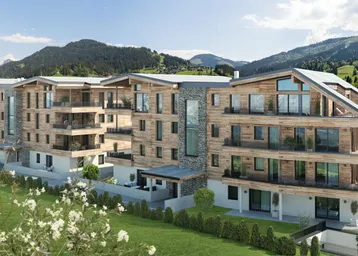 Modernes Mehrfamilienhaus in alpiner Architektur mit Holzfassade, Balkonen und Bergblick.