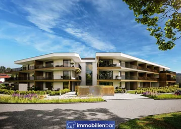 Moderne Wohnanlage mit mehreren Balkonen und gepflegter Außenanlage unter blauem Himmel.