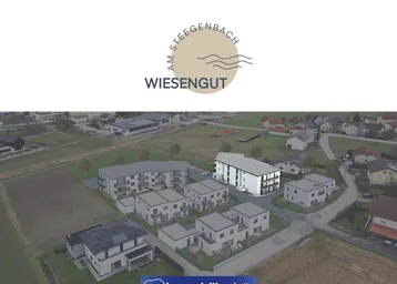 Luftaufnahme einer modernen Wohnsiedlung mit Neubauten und umliegender Natur.