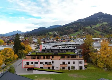 Moderne Wohnanlage in alpiner Umgebung mit Bergblick und Balkonen.