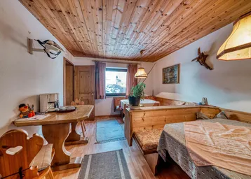Gemütlicher Essbereich im alpinen Stil mit Holztäfelung an Decke und Wänden sowie traditionellen Sitzbänken.
