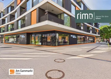 Modernes Gebäude mit Geschäftsflächen im Erdgeschoss und Wohnungen darüber, an einer belebten Straße gelegen.