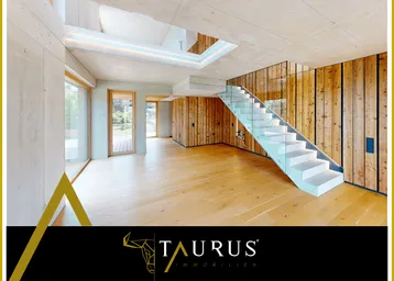 Geräumiger Wohnbereich mit Holzboden, Sichtbetonwänden und moderner Glas-Beton-Treppe.