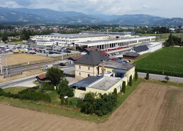 Luftaufnahme des Anwesens mit Bahngleisen und einem Industriegebäude in der Ferne, umgeben von Feldern.