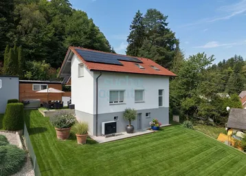 Modernes Einfamilienhaus mit Photovoltaikanlage, gepflegtem Garten, Terrasse und Whirlpool in grüner Umgebung.
