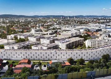 Luftaufnahme eines weitläufigen Wohnkomplexes in einer städtischen Umgebung mit viel Grün.
