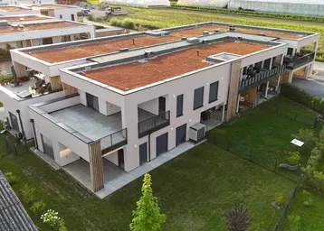 Moderne Wohnanlage mit Flachdächern und begrünten Dächern in ländlicher Umgebung.