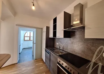 Moderne Einbauküche mit dunklen Unterschränken, hellen Oberschränken und integrierten Geräten.