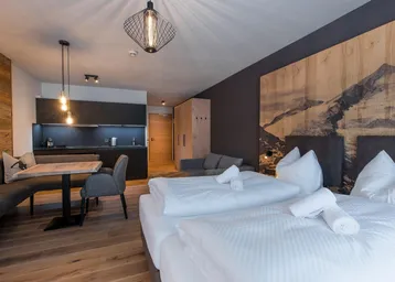 Modernes Apartment mit Schlafbereich, integrierter Küche und Essplatz in einem offenen Raum.