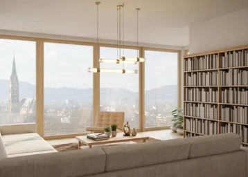 Helles Wohnzimmer mit raumhohen Fenstern, Bücherregal und weitem Blick über die Stadt.