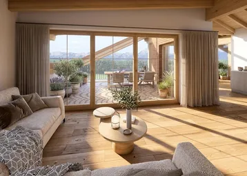 Helles Wohnzimmer mit Holzboden, bequemen Sofas und Zugang zu einer großen Terrasse.