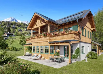 Modernes Chalet mit Holzfassade, großem Balkon, Terrasse und Bergblick in grüner Umgebung.