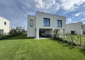 Modernes Einfamilienhaus mit gepflegtem Rasen und überdachter Terrasse im Freien.
