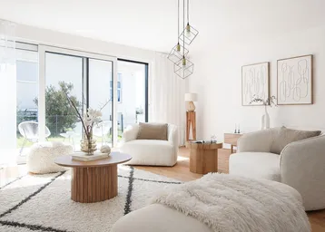 Helles Wohnzimmer mit modernen Möbeln, Holzboden und Zugang zur Terrasse.