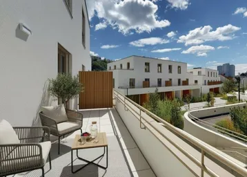 Geräumige Terrasse mit modernen Gartenmöbeln und Blick auf die umliegende Wohnanlage unter blauem Himmel.