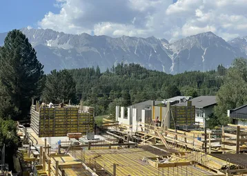 Baustelle für neue Gebäude mit Blick auf die majestätischen Berge und umliegende Naturlandschaft.