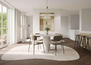 Offener Wohn- und Essbereich mit elegantem Marmortisch, Holzboden und großen Fenstern zum Garten.