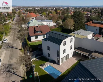 Moderne Villa mit Pool und Garten in einer ruhigen Wohngegend aus der Vogelperspektive.