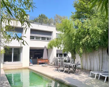 Moderne Villa mit privatem Pool, sonniger Terrasse und üppiger Bambusbepflanzung.