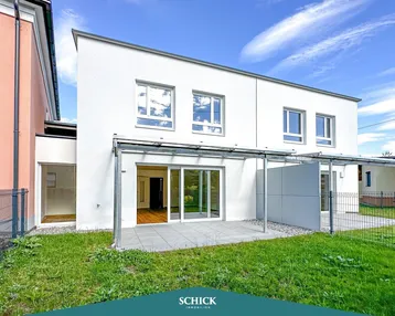 Moderne Doppelhaushälfte mit großer Terrasse und Garten, ideal für sonnige Tage im Freien.