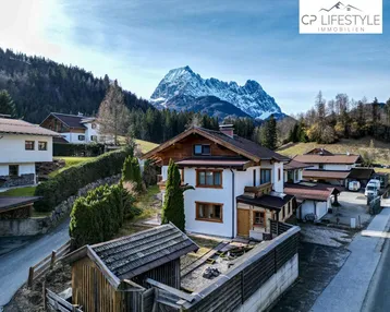 Traditionelles Haus mit Holzelementen und beeindruckendem Bergblick in ländlicher Umgebung.