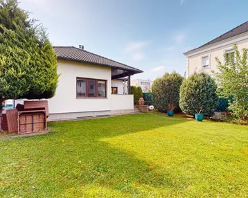 Großer, gepflegter Gartenbereich mit Rasenfläche und Bäumen neben dem Haus.