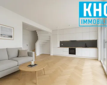Helles, offenes Wohnzimmer mit integrierter Küche, Parkettboden und Zugang zu großen Fenstern.
