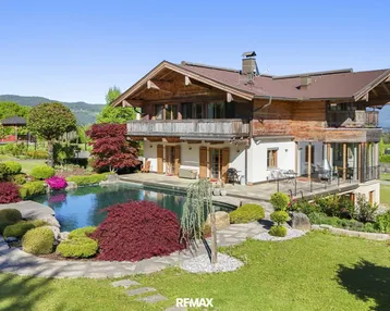 Großzügiges Anwesen mit traditionellem Holzhaus, weitläufigem Garten und privatem Swimmingpool in alpiner Umgebung.
