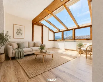 Helles Wohnzimmer mit großen Dachfenstern, Holzbalken und Bergblick, ausgestattet mit gemütlichen Möbeln.