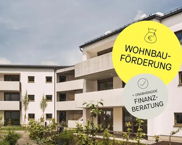 Moderne weiße Wohngebäude mit Balkonen und gepflegter Außenanlage unter blauem Himmel.