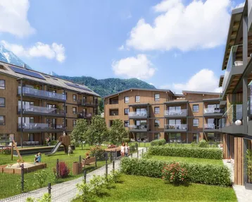Moderne Wohngebäude mit Holzfassaden, Balkonen, Spielplatz und Bergblick in einer grünen Umgebung.