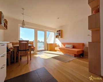 Helles Wohn- und Esszimmer mit Holzboden, Zugang zur Terrasse und viel Tageslicht.