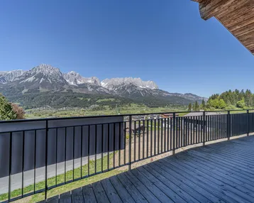 Große Holzterrasse mit Metallgeländer und weitem Blick auf die umliegende Berglandschaft.