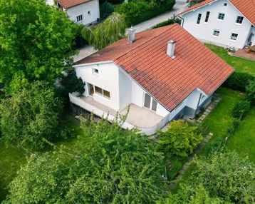 Detaillierte Luftaufnahme des Hauses mit großer Terrasse und gepflegtem Garten.