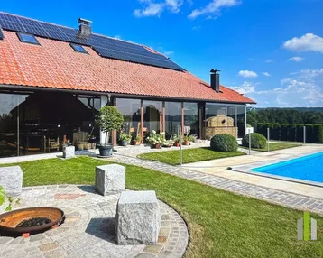 Großzügiger Außenbereich mit Pool, Liegewiese, Feuerstelle und Solaranlage auf dem Dach.