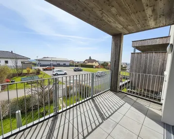 Geräumiger Balkon mit Fliesenboden und Blick auf die umliegende Wohngegend und Grünflächen.