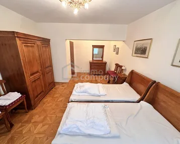 Schlafzimmer mit zwei Einzelbetten, traditionellen Holzmöbeln und klassischem Parkettboden.