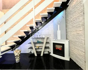 Moderne Treppe mit schwarzen Stufen, dekorativem Elektrokamin und beleuchteten Regalen.