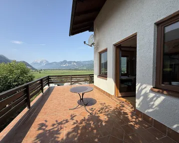 Geräumige geflieste Terrasse mit kleinem Tisch und herrlichem Blick auf die Bergwelt.