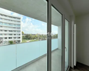 Geräumiger Balkon mit moderner Verglasung und weitem Blick auf die Umgebung und andere Gebäude.