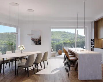 Heller, offener Wohn-Essbereich mit moderner Küche, Holzboden und Zugang zur Terrasse mit Bergblick.