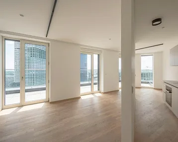 Heller, offener Wohnbereich mit Holzboden und Zugang zu mehreren Balkonen mit Stadtblick.