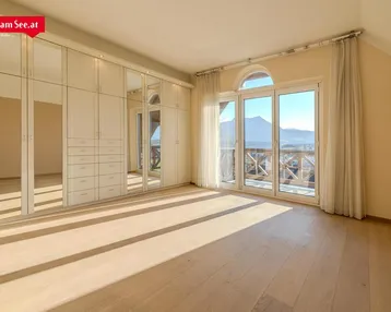 Geräumiges Schlafzimmer mit großem Einbauschrank, Holzboden und Balkonzugang.