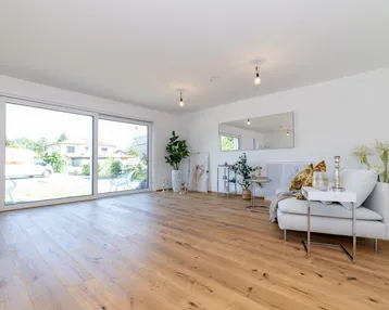 Helles Wohnzimmer mit großen Schiebetüren, Holzboden und moderner, heller Einrichtung.