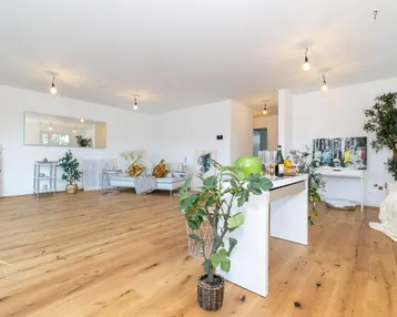 Helles und geräumiges Wohnzimmer mit modernem Holzboden und stilvoller Dekoration, ideal für offenes Wohnen.